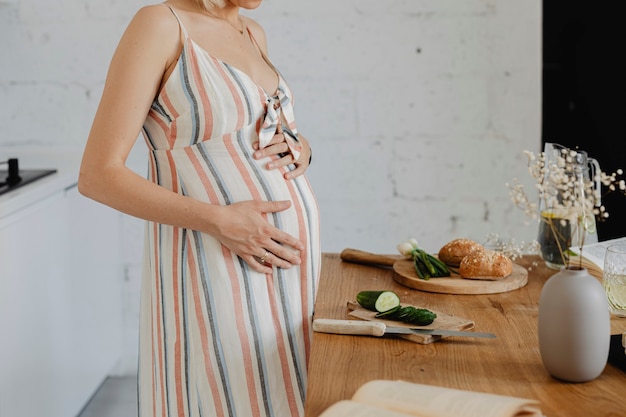 Donna incinta che cucina in una cucina