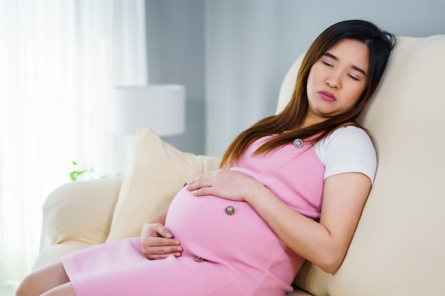 Donna incinta che dorme sul divano del soggiorno