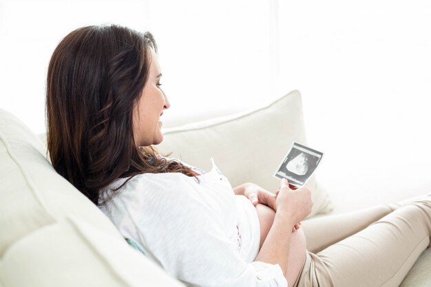 Donna incinta che esamina le ecografie sullo strato