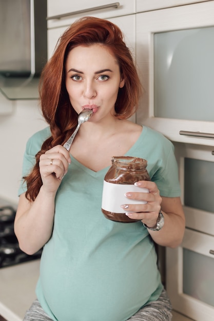 Donna incinta che gode mangiando cioccolato