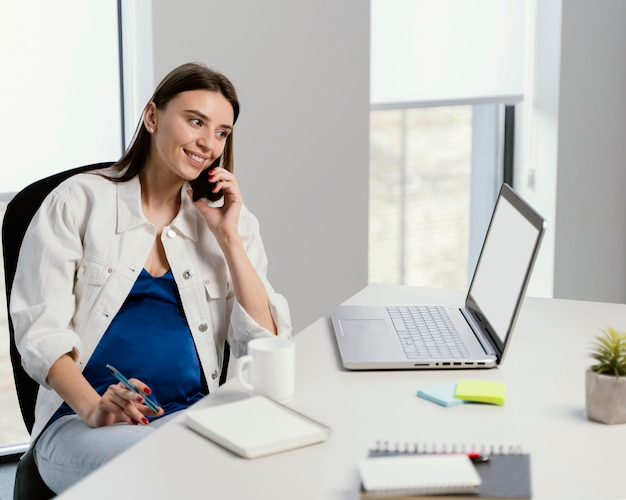 Donna incinta che ha una chiamata al lavoro