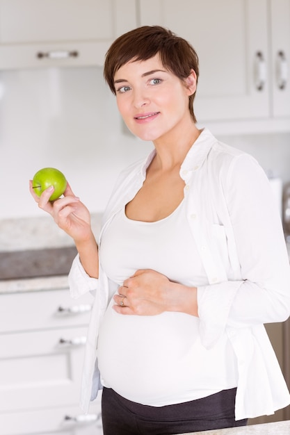 Donna incinta che mangia una mela