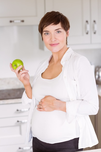 Donna incinta che mangia una mela