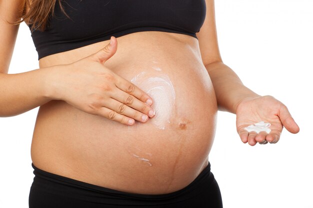 donna incinta che massaggia la sua pancia con unguento contro le smagliature