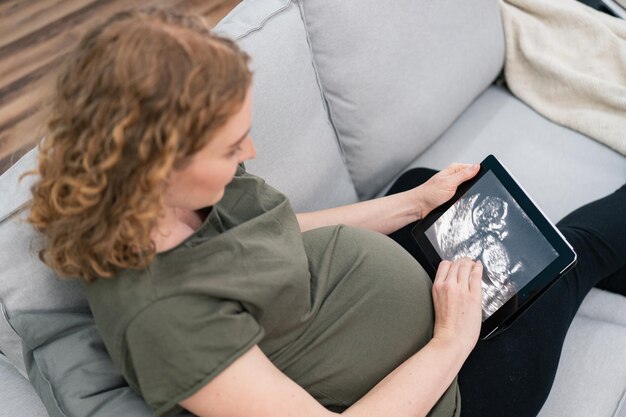 Donna incinta che osserva nell'immagine ecografica del suo bambino