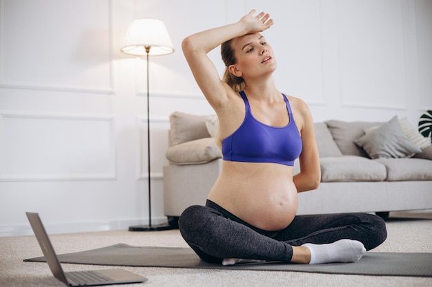 Donna incinta che pratica yoga a casa