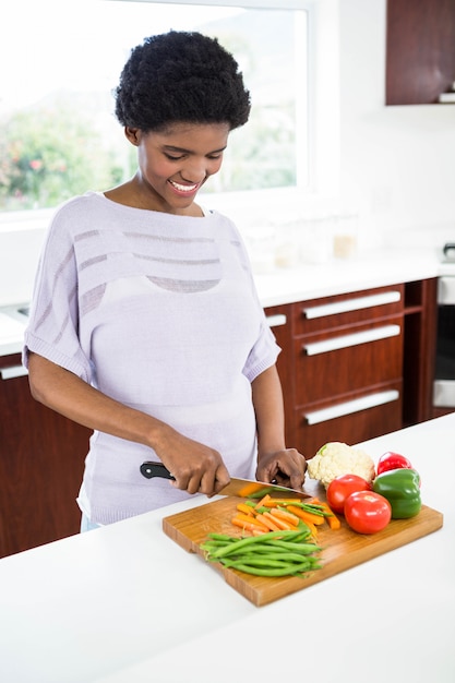 Donna incinta che prepara le verdure in cucina