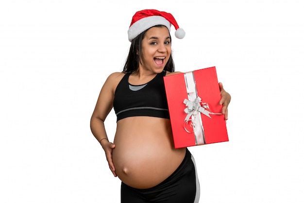 Donna incinta che tiene un contenitore di regalo di natale.