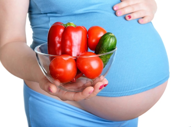 Donna incinta che tiene una verdura fresca