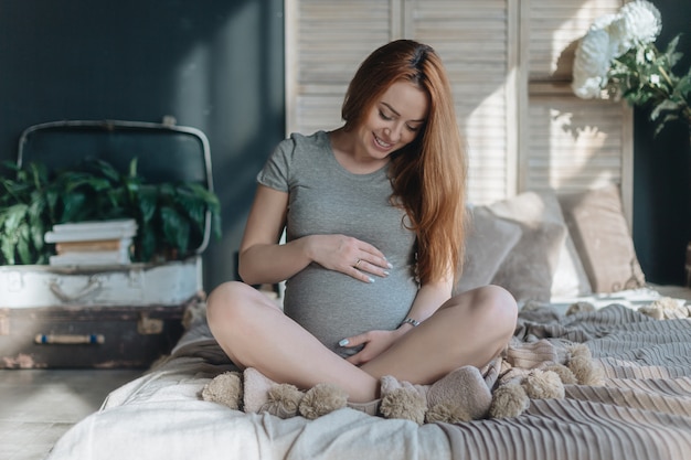 Donna incinta che tocca e che guarda alla sua pancia