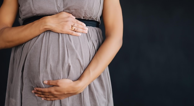 Donna incinta che tocca la sua pancia su sfondo blu