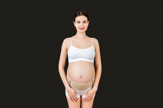 Donna incinta che usando una cintura addominale