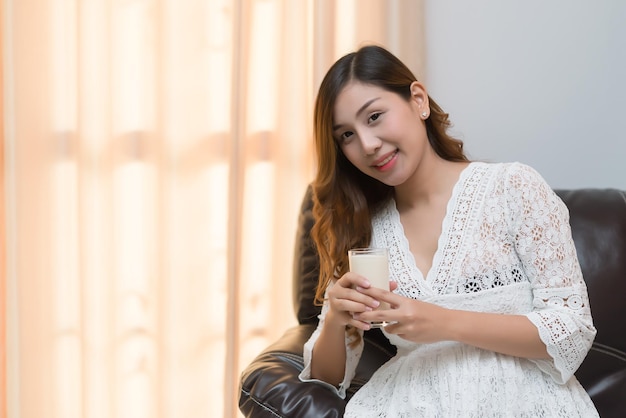 Donna incinta con il latte in mano Bere latte fa bene alla gravidanza