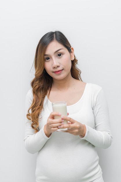 Donna incinta con il latte in mano Bere latte fa bene alla gravidanza