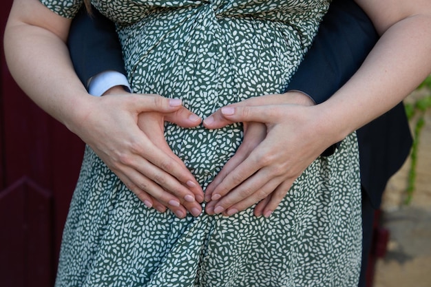 Donna incinta con il marito delle mani che tocca il concetto di gravidanza della pancia