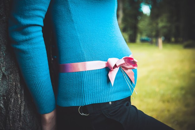 Donna incinta con un nastro rosa