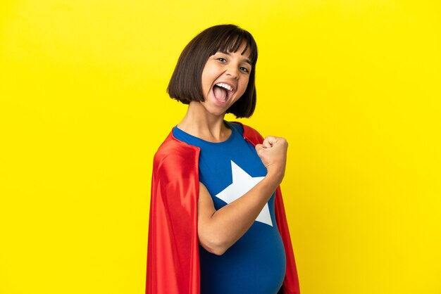 Donna incinta del super eroe isolata su fondo giallo che celebra una vittoria