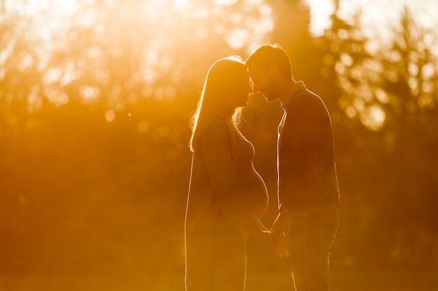 Donna incinta e il suo uomo amorevole che propone alla sosta di autunno