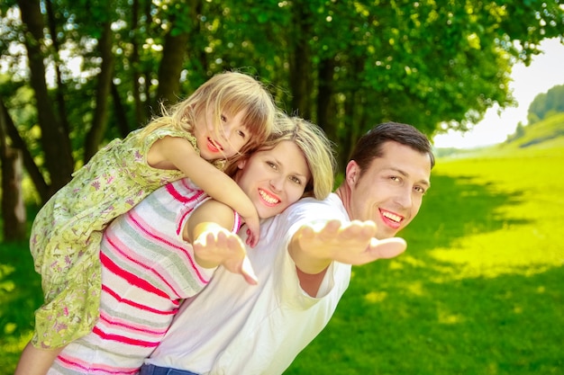 Donna incinta felice con la sua famiglia sulla natura in un parco