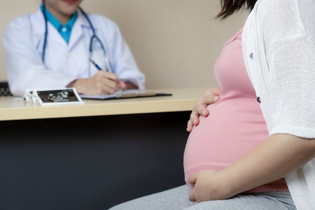 Donna incinta felice visita medico ginecologo in ospedale o in clinica per consulente di gravidanza.