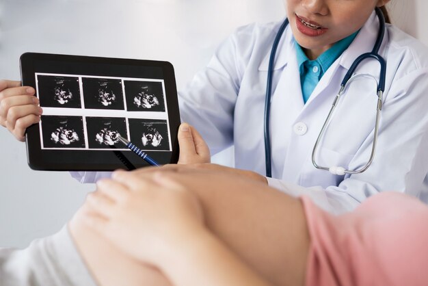 Donna incinta felice visita medico ginecologo in ospedale o in clinica per consulente di gravidanza.