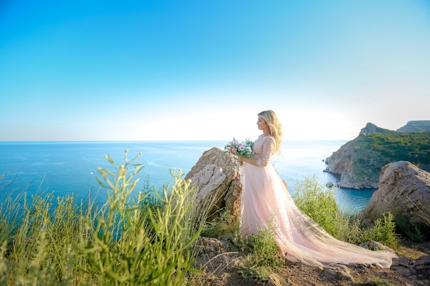 Donna incinta in natura. Madre futura della bella donna in vestito lungo bianco all'aperto