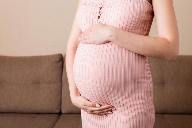 Donna incinta in un bel vestito in piedi sulla casa