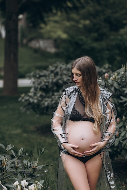 donna incinta in un impermeabile nel parco