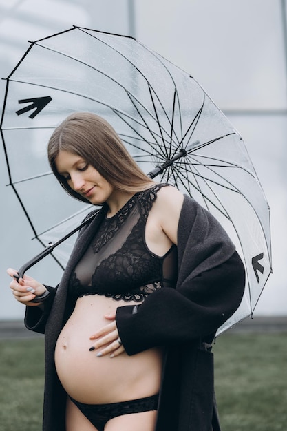 donna incinta in un impermeabile nel parco