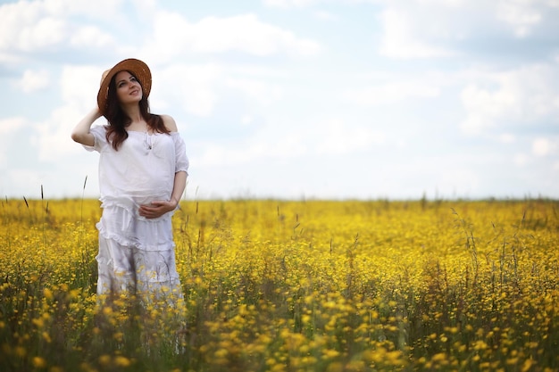 Donna incinta in un vestito in un campo di fiori