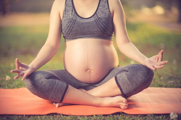 donna incinta sana facendo yoga nella natura all&#39;aperto