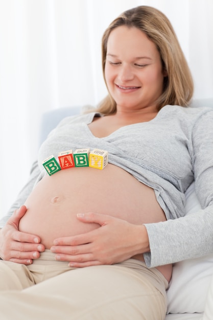 Donna incinta sveglia con le lettere della mamma sul suo rilassamento della pancia