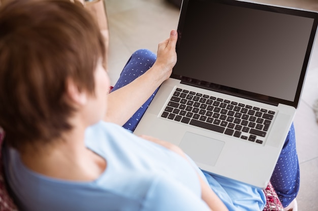 Donna incinta usando il suo computer portatile