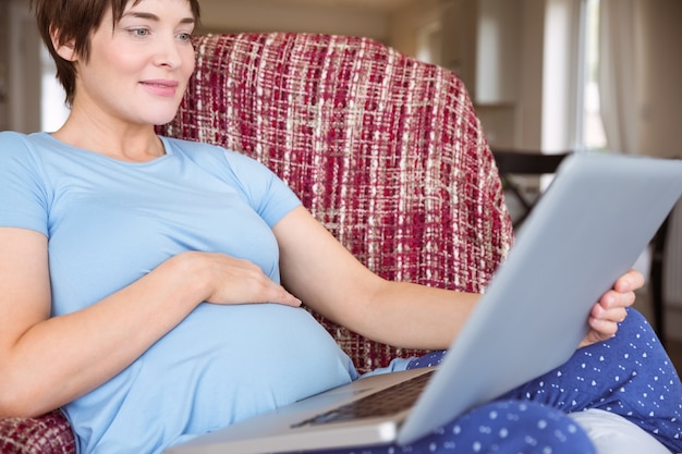Donna incinta usando il suo computer portatile