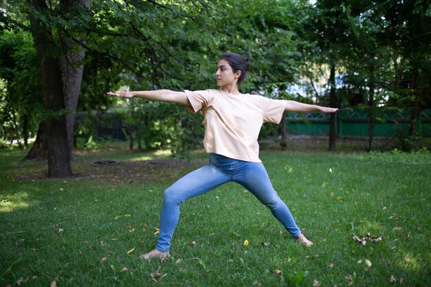 Donna indiana che fa yoga nel parco estivo all'aperto