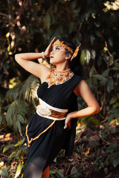 Donna indiana che indossa un abito nero con una corona d'oro e una collana d'oro sul corpo