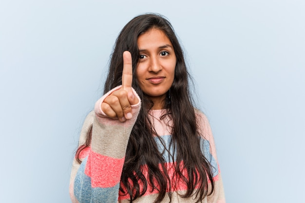 Donna indiana di giovane modo che mostra numero uno con il dito.