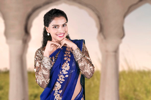 Donna indiana timida che indossa abiti di saree blu