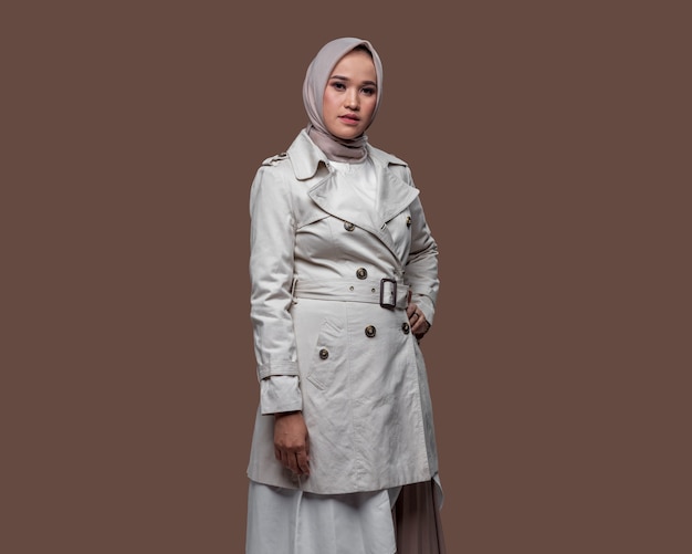 Donna indonesiana che indossa l'hijab in posa indossando una giacca bianca isolata su sfondo semplice