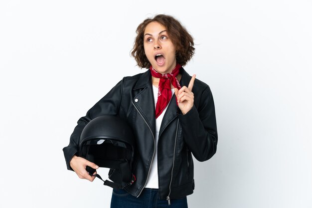 Donna inglese che tiene un casco del motociclo su bianco pensando un'idea che punta il dito verso l'alto