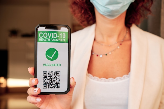 Donna irriconoscibile che mostra il codice qr per il certificato di vaccinazione per Covid-19