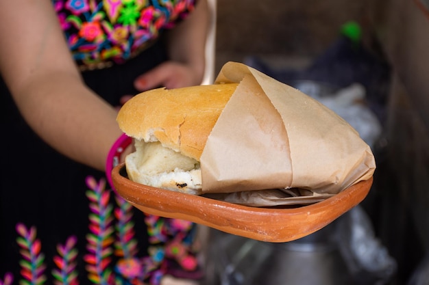 Donna irriconoscibile con una tradizionale torta de tamal messicana