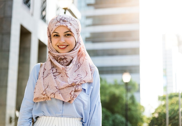 Donna islamica in piedi e sorridente in città