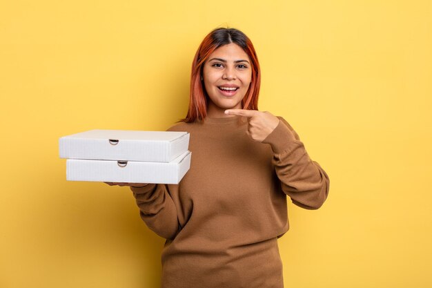 Donna ispanica che sembra eccitata e sorpresa che indica il concetto di pizza da asporto laterale