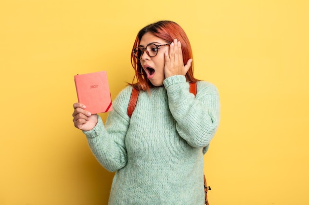 Donna ispanica che si sente felice eccitato e sorpreso studente e concetto di calendario