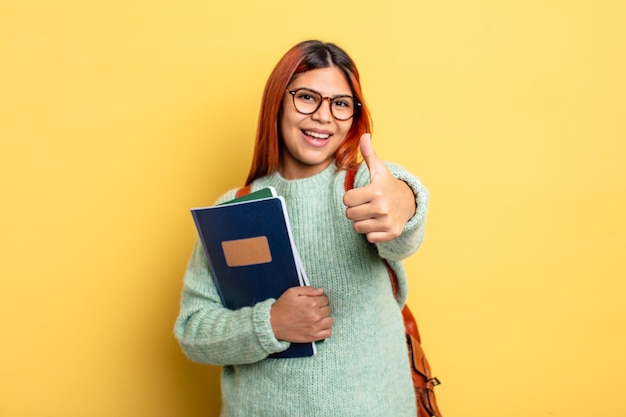 Donna ispanica che si sente orgogliosa di sorridere positivamente con il pollice in alto concetto di studente