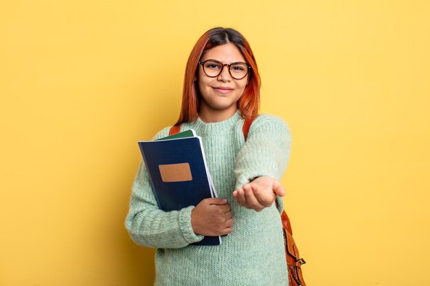 Donna ispanica che sorride felicemente con amichevole e offrendo e mostrando un concetto. concetto di studente