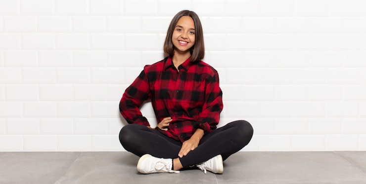 Foto donna ispanica che sorride felicemente con una mano sull'anca e l'atteggiamento fiducioso, positivo, orgoglioso e amichevole