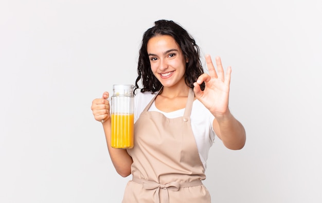 Donna ispanica graziosa chef che prepara un succo d'arancia