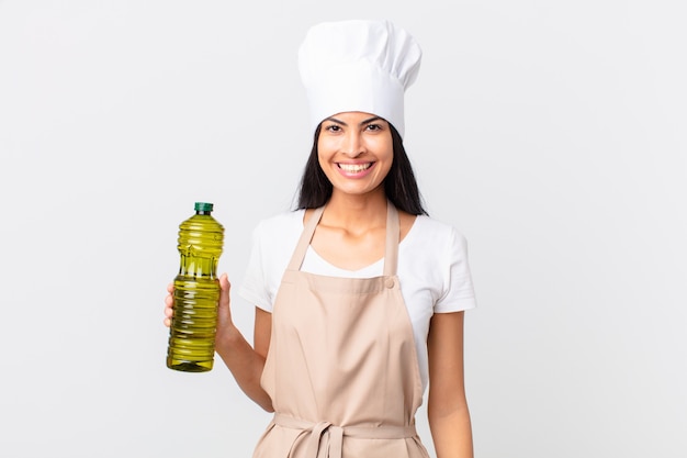 Donna ispanica piuttosto chef in possesso di una bottiglia di olio d'oliva.